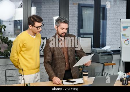 Two professionals engage in discussion about tasks during onboarding at the office workspace. Stock Photo