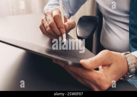 Close-up of a business professional signing a digital document on a tablet with a stylus. Concept of e-signature, contract approval, workflow digitali Stock Photo