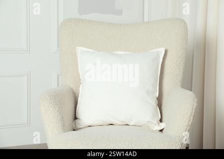 Blank soft pillow on cozy armchair indoors Stock Photo