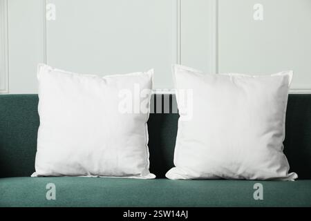 Blank soft pillows on cozy couch indoors Stock Photo