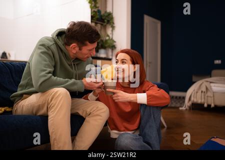 Happy couple drinking tea in cozy home atmosphere enjoying pleasant conversation Stock Photo