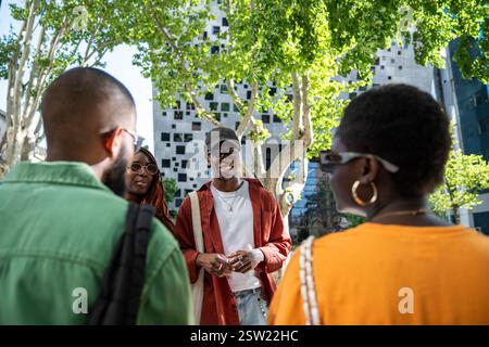 Group of cheerful happy african american students friends chatting outside after university lectures Stock Photo