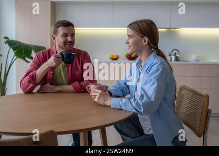 Sentimental loving couple spending pastime together weekends at home, drinking tea, coffee, speaking Stock Photo
