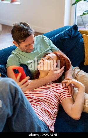 Young couple man and woman resting on sofa, enjoying married life Stock Photo