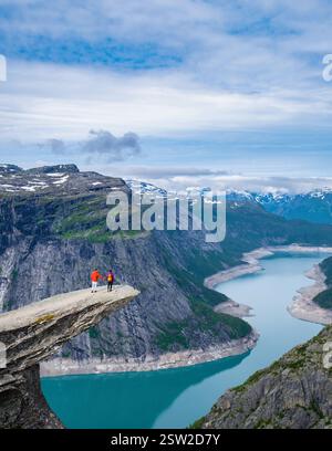 Two Hikers on the Trolltunga Cliff in Norway Stock Photo