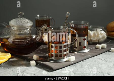 Glasses of tea in metal holders served on grey textured table Stock Photo
