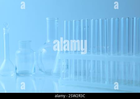 Different laboratory glassware with light blue liquid isolated on white ...