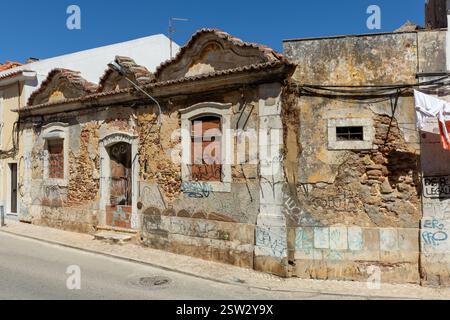 An old abandoned house in a street with bricked up windows and front door. Ornaments still present. Stock Photo