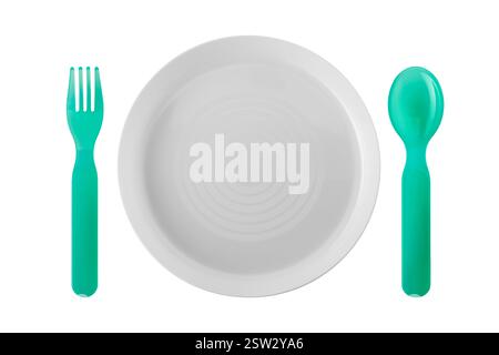 Plate between Plastic children's spoon and fork in top view on table arranged, isolated on white with clipping path included Stock Photo