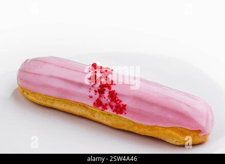 Eclairs with pink glaze on a white plate Stock Photo