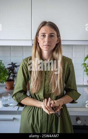 Portrait tired fatigued blonde middle aged woman calm looking at camera holding eyeglasses in hands. Stock Photo