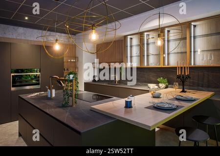 Contemporary kitchen showcasing stylish design, integrated appliances, and a central island, illuminated by spherical pendant lights Stock Photo