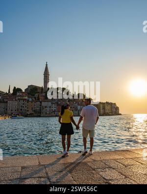 Couple enjoying a romantic sunset stroll along the waterfront in Rovinj, Croatia Stock Photo