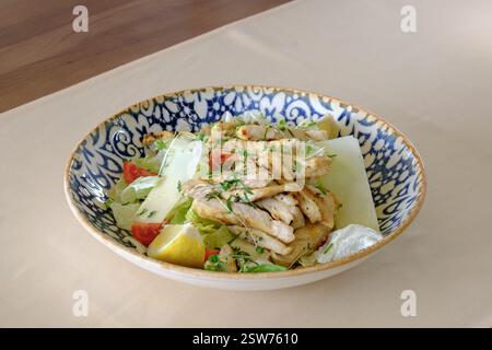 Grilled chicken salad with romaine lettuce parmesan cheese and lemon Stock Photo