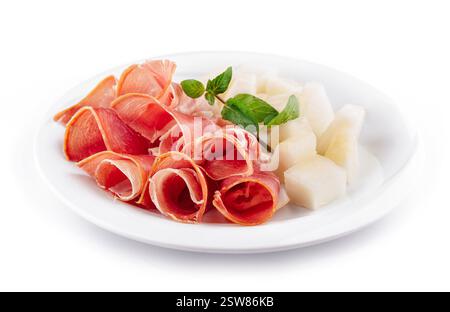 Plate with slices of prosciutto and melon garnishing with mint Stock Photo
