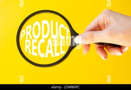 Product recall symbol. Concept words Product recall on magnifying glass. Beautiful yellow background. Businessman hand. Business and Product recall co Stock Photo
