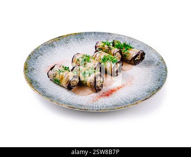 Delicious eggplant rolls stuffed with nuts and herbs lying on plate Stock Photo