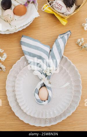 Easter egg wrapped in linen napkin in the shape of bunny with ears. Happy Easter  Stock Photo