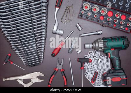 Various auto mechanic tools with cordless impact wrench on a work table. Stock Photo