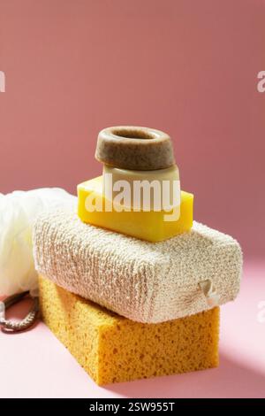 Set of bath accessories, sponges of different sizes and shapes and handmade soap on a pink background. Individual set for body skin care. Stock Photo