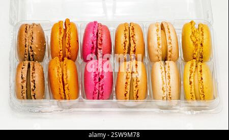 Colourful traditional French macaroons cakes inside plastic box isolated on white Stock Photo