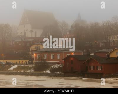 porvoo town misty view across river of red wooden warehouses and colourful houses of the old town and the white cathedral at the top of the hill Stock Photo