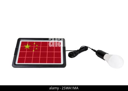 Portable solar panel in the shape of China flag connected to light bulb isolated on white background (close-up). Concept of renewable energy Stock Photo