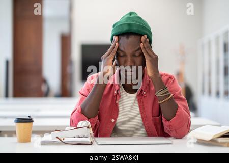 Exhausted black student man suffering from anxiety or panic attack after long prepare exam on laptop Stock Photo
