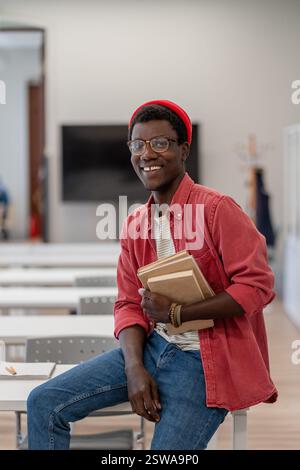 Happy smiling African guy university student in classroom or library Stock Photo