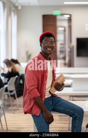 Happy smiling African guy university student in classroom or library Stock Photo