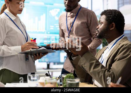 Chairman of the advisory board examines potential company expansion, team supervisor and the staff members presenting data visualizations. CEO and investors seek to boost earnings. Stock Photo