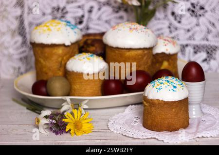 A lot of Easter bread on the table with Easter eggs and spring flowers. Food for Easter Stock Photo