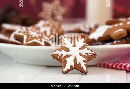 Spicy ginger cookies in a star-shaped glaze, milk and many cookies on a plate. Winter New Year's pastries, background Stock Photo