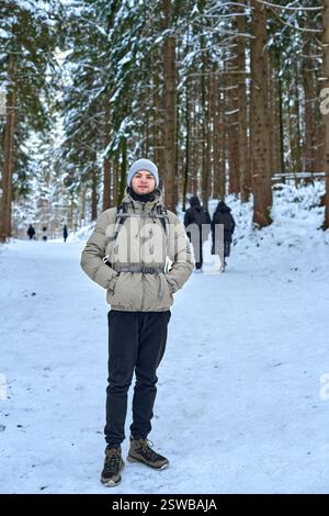 Winter Wonderland Adventure Young Man Hiking Snow Covered Forest Path Surrounded by Towering Pine Trees Serene Nature Exploration Scene Capturing Outd Stock Photo