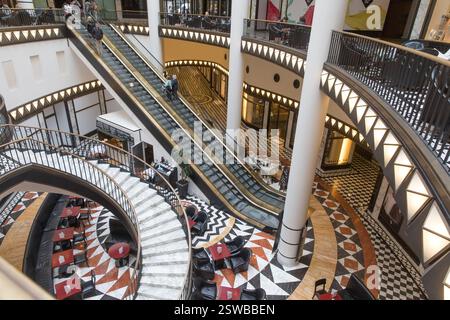 High-ceilinged, ornate escalators and spiral staircase at Friedrichstraße Stock Photo