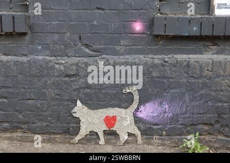 Street art mosaic cat with heart on a dark brick wall Friedrichshain Stock Photo