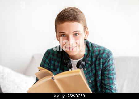 Happy teenager enjoying his book, spending time at home Stock Photo