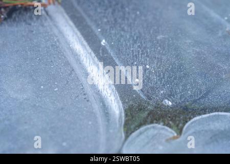 Intricate patterns of ice crystals and air bubbles frozen on a surface Nature's delicate artistry in winter's embrace Stock Photo