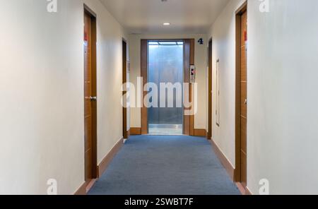 There is an open elevator at the end of the hallway. Stock Photo
