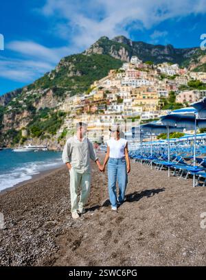 Couple strolling hand-in-hand along the pebbled beach of Positan Stock Photo