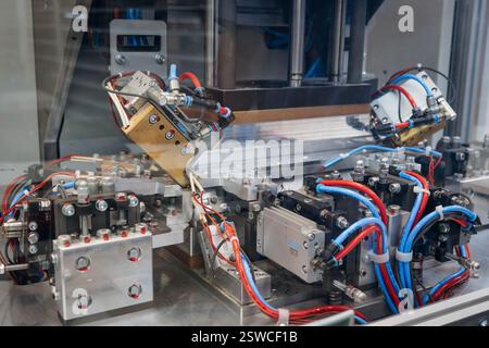 Automated machine component featuring pneumatic and electrical connections for industrial processes Stock Photo