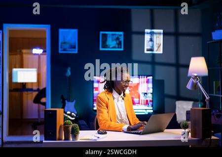Worker analyzing data charts on laptop at desk, interpreting statistical graphs, identifying trends, compiling analytical reports, using data analysis software to process and visualize information Stock Photo