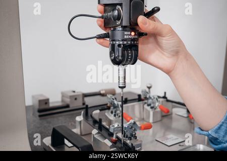 Precision engineering: A coordinate measuring machine probe analyzes a manufactured part Stock Photo