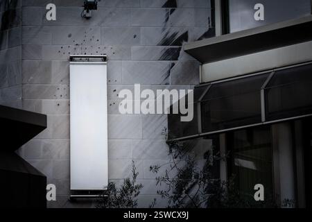 An empty vertical white rectangular sign displayed on a modern office facade in Belgium. Its minimalistic design stands out, offering ample branding s Stock Photo