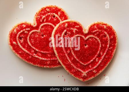 Two heart shaped Valentines Day sugar cookies on a white background. Stock Photo
