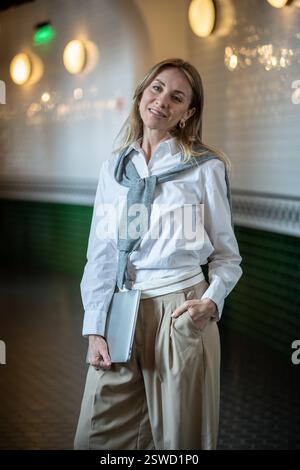 Smiling woman standing in hallway with laptop. Adult student, female programmer, recruiter job task Stock Photo