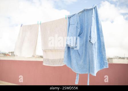 Clothes drying on a clothesline in a sunny terrace, perfect for outdoor lifestyle, laundry, and home chores themes. Stock Photo