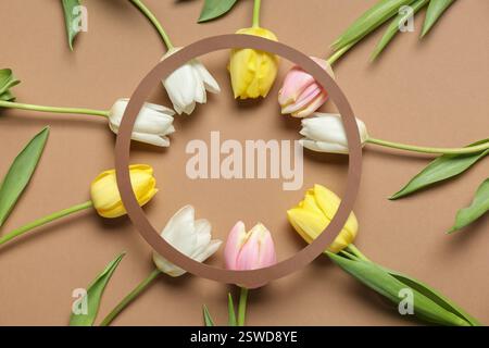 Frame made of beautiful tulip flowers on brown background Stock Photo