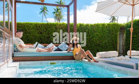 Freelancer enjoys tropical paradise while working remotely by the pool in Thailand Stock Photo