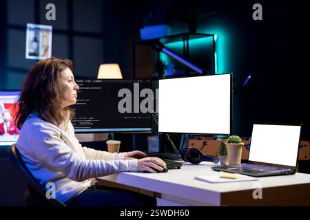 Cybersecurity expert using isolated screen computer to look for security vulnerabilities and injected malware. Programmer installing fortified code on mockup PC and laptop to prevent cyber attacks Stock Photo